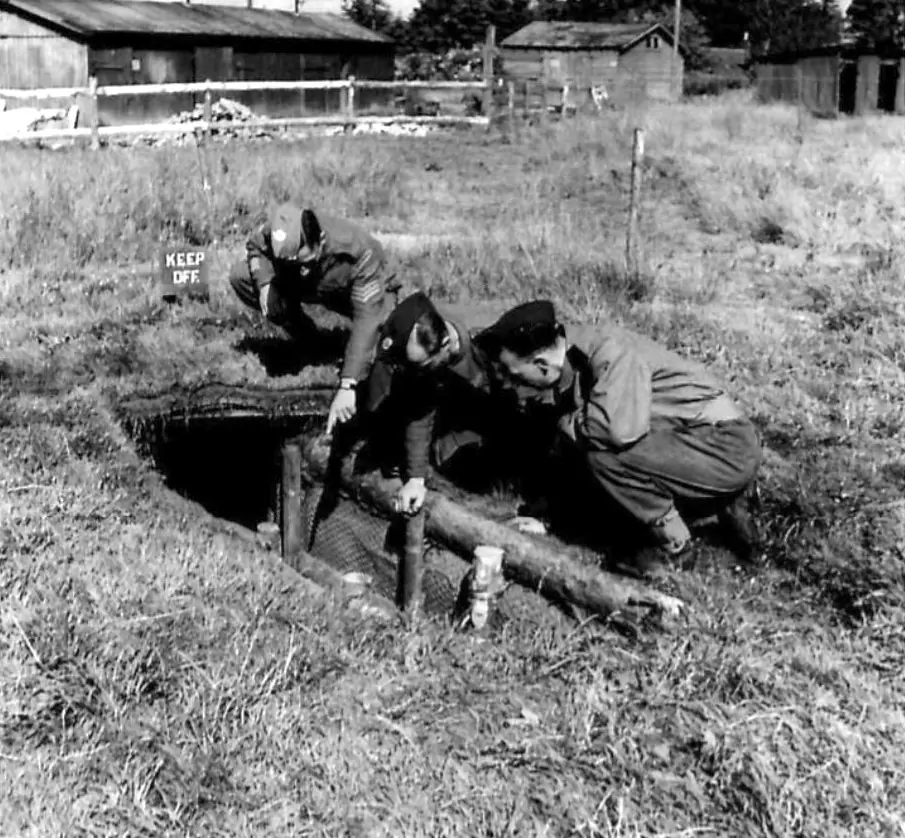 Sgt S T Goldwin, Royal Engineers for 4 years from Windsor, a printer in civilian life [left] showing slit trench to Leading Aircraftsman, RAF for 2 years,  C Osborne from Brandon, Suffolk a plumber in civilian life [centre]